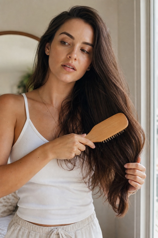 Woman gently brushing out tangled hair