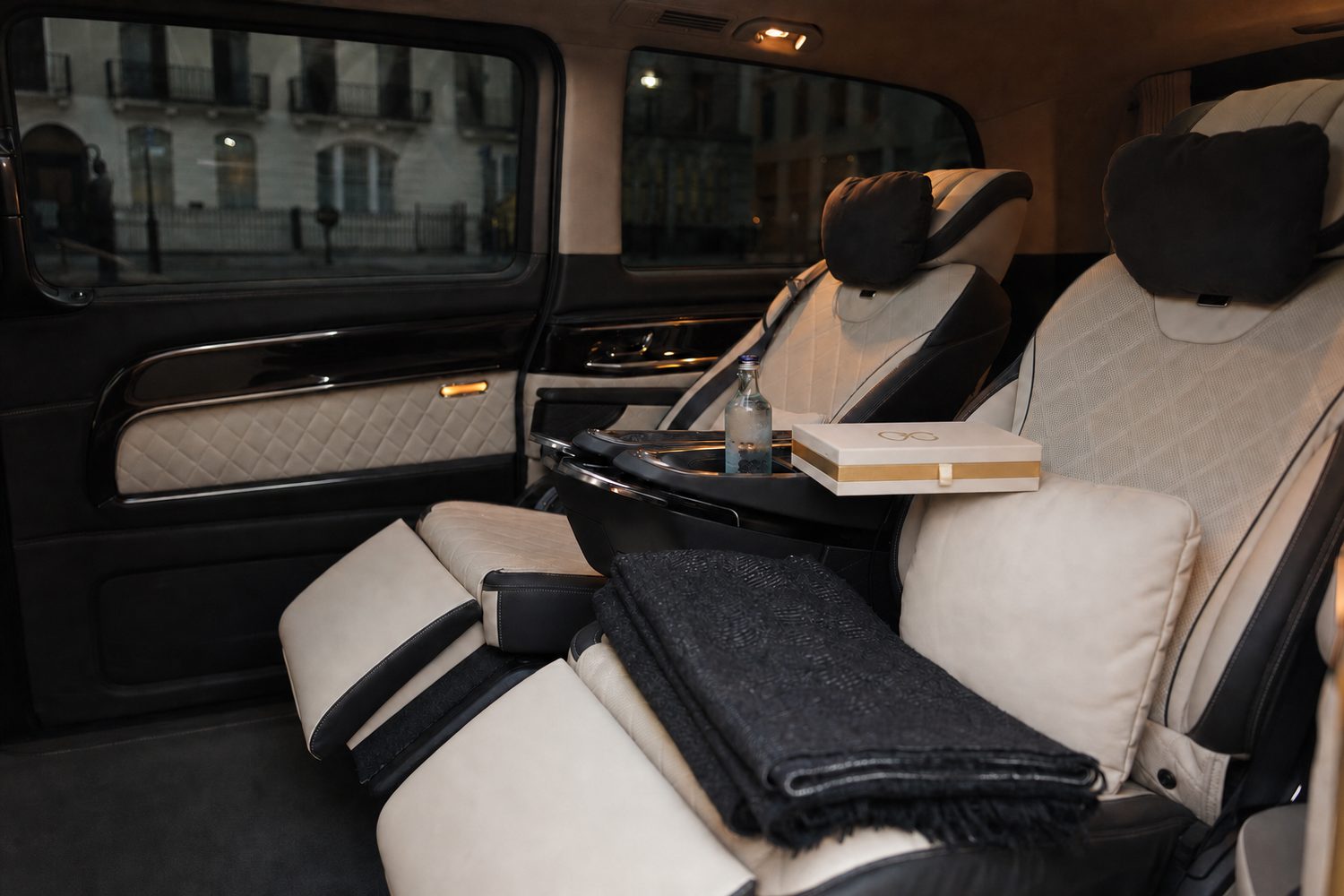 Chauffeur beside a black Rolls-Royce saloon