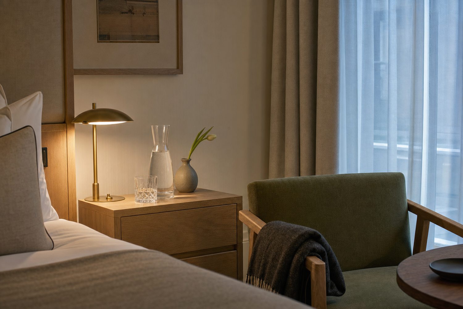 A partner hotel suite prepared for recovery — propped pillows, water and the aftercare kit on the desk